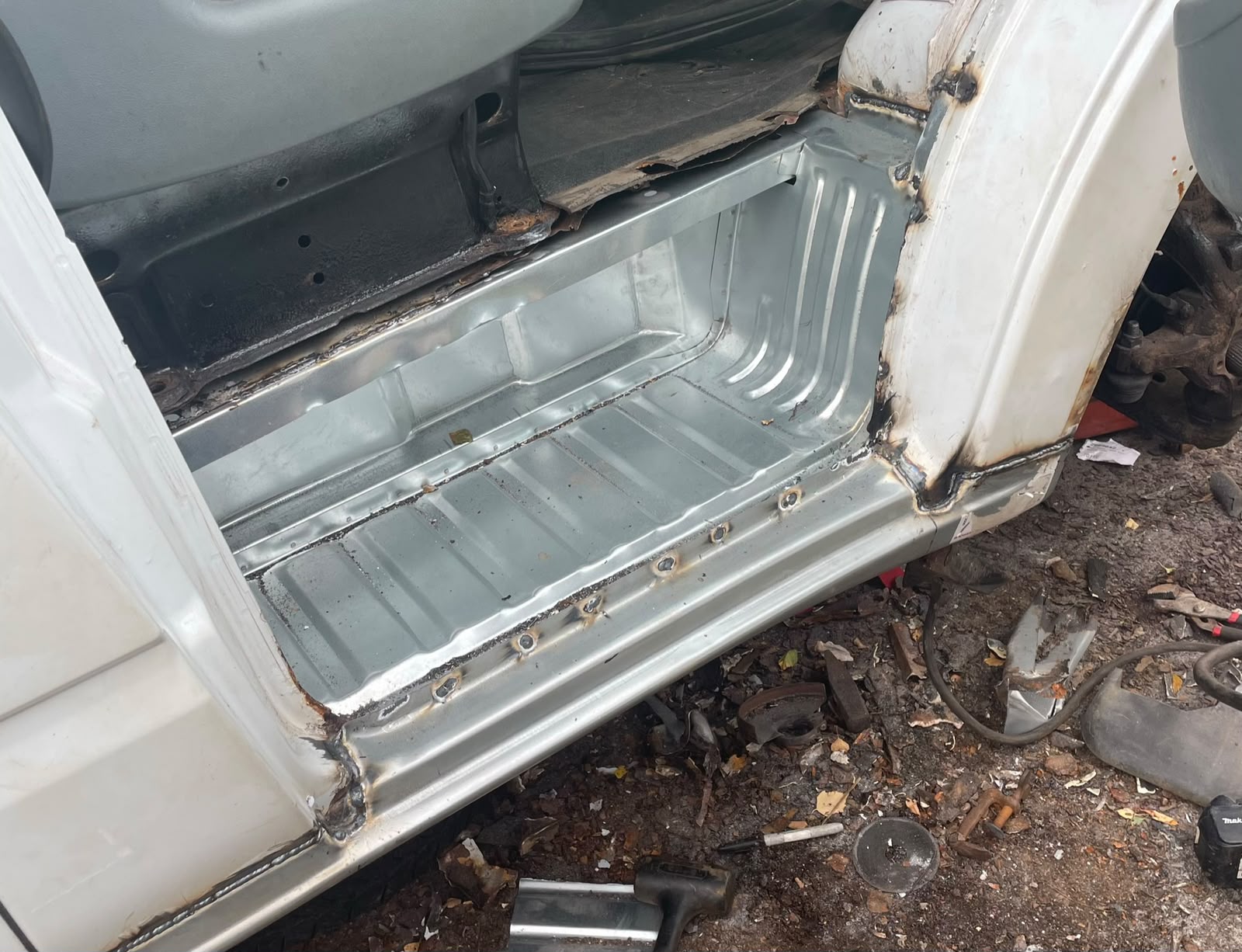 Replacement sill and floor section welded into a vehicle